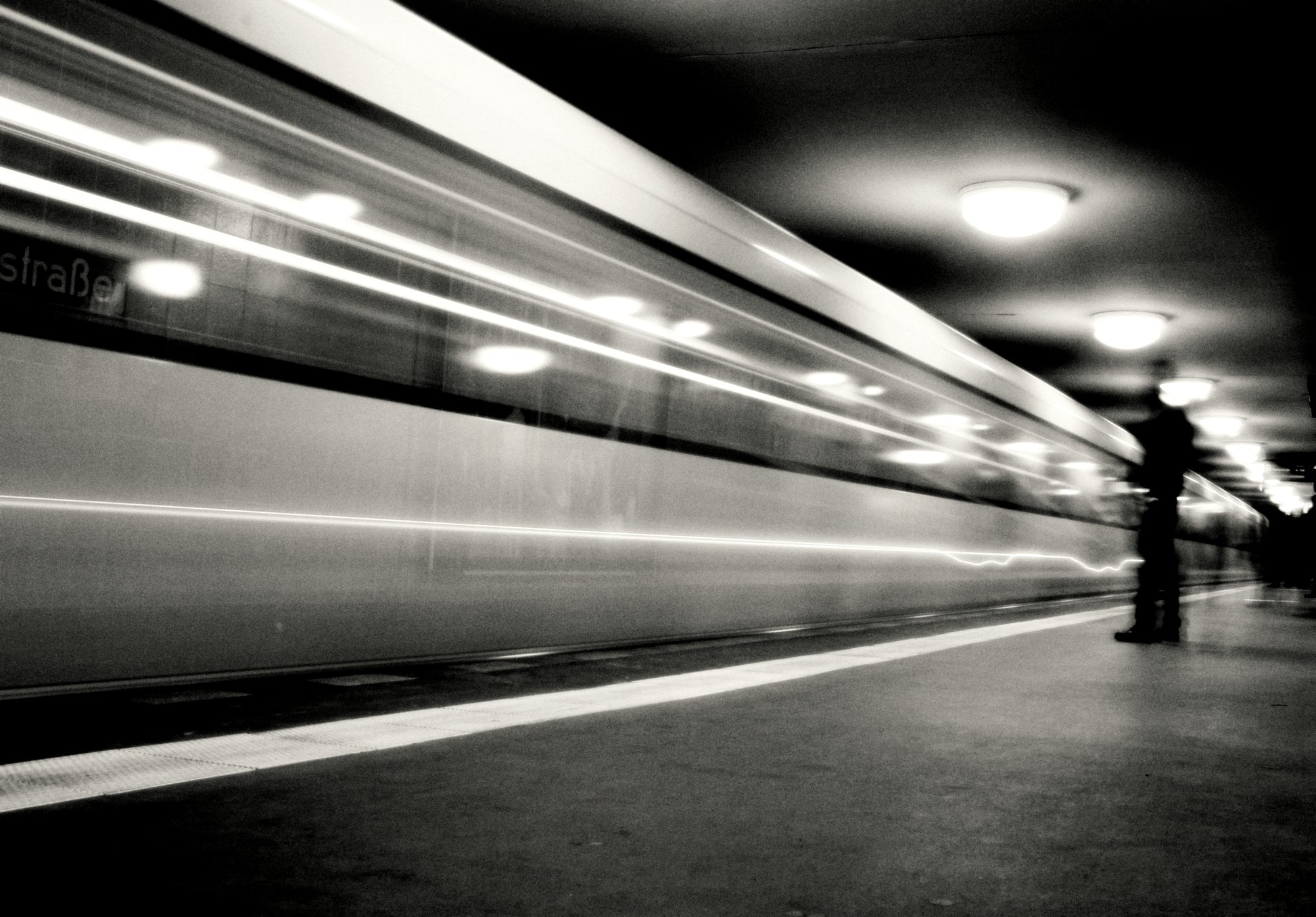 künstlerische Schwarz-Weiß-Fotografie einer U-Bahn-Station mit einfahrender U-Bahn